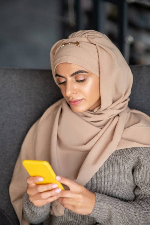 muçulmana utilizando seu celular